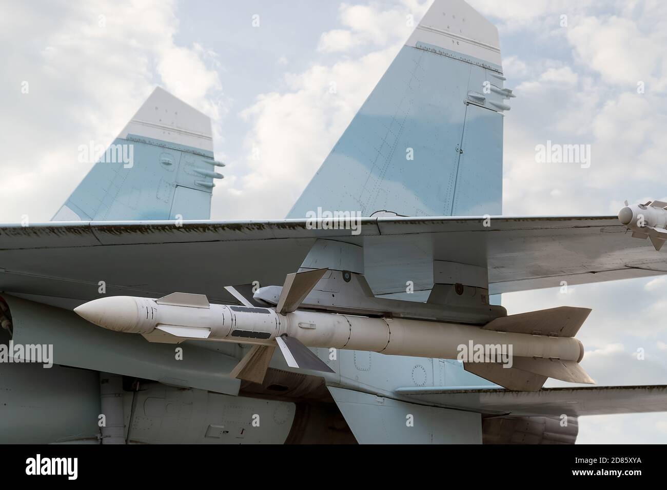 Aereo militare con razzi sullo sfondo del cielo nuvoloso. Foto Stock