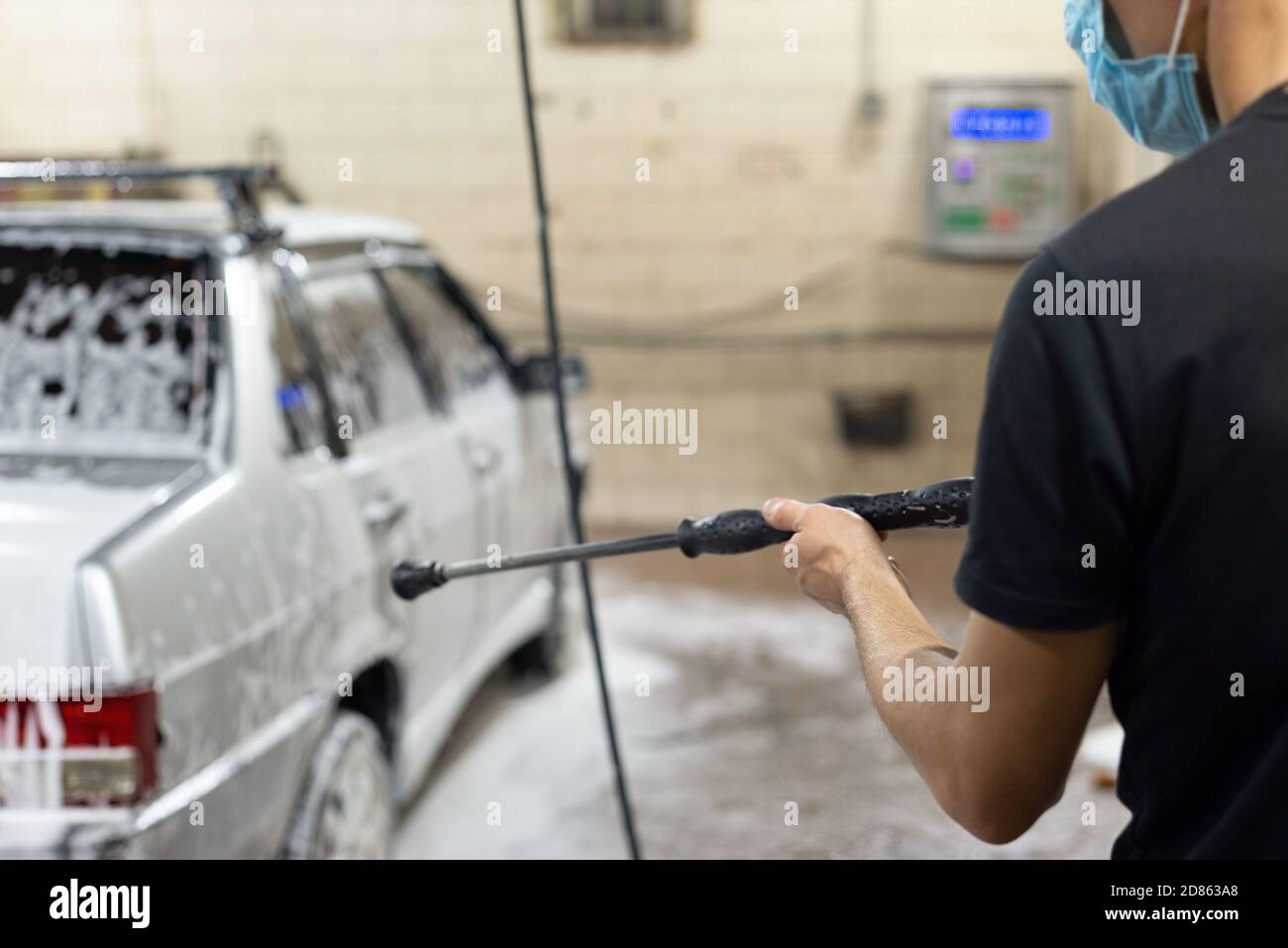 coronavirus pulizia della macchina, lavando la carrozzeria con un pulitore da soluzione di sapone. Il lavoro di tecnici automatici durante il periodo di quarantena COV Foto Stock
