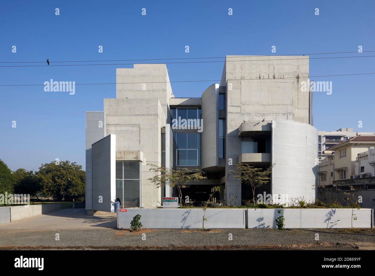 Vista esterna generale con pareti in movimento. Gihed Credai, Ahmedabad, India. Architetto: Matharoo Associates, 2020. Foto Stock