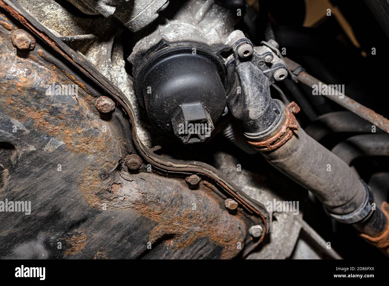 Filtro dell'olio avvitato nel motore diesel sul fondo del motore accanto alla coppa dell'olio. Foto Stock