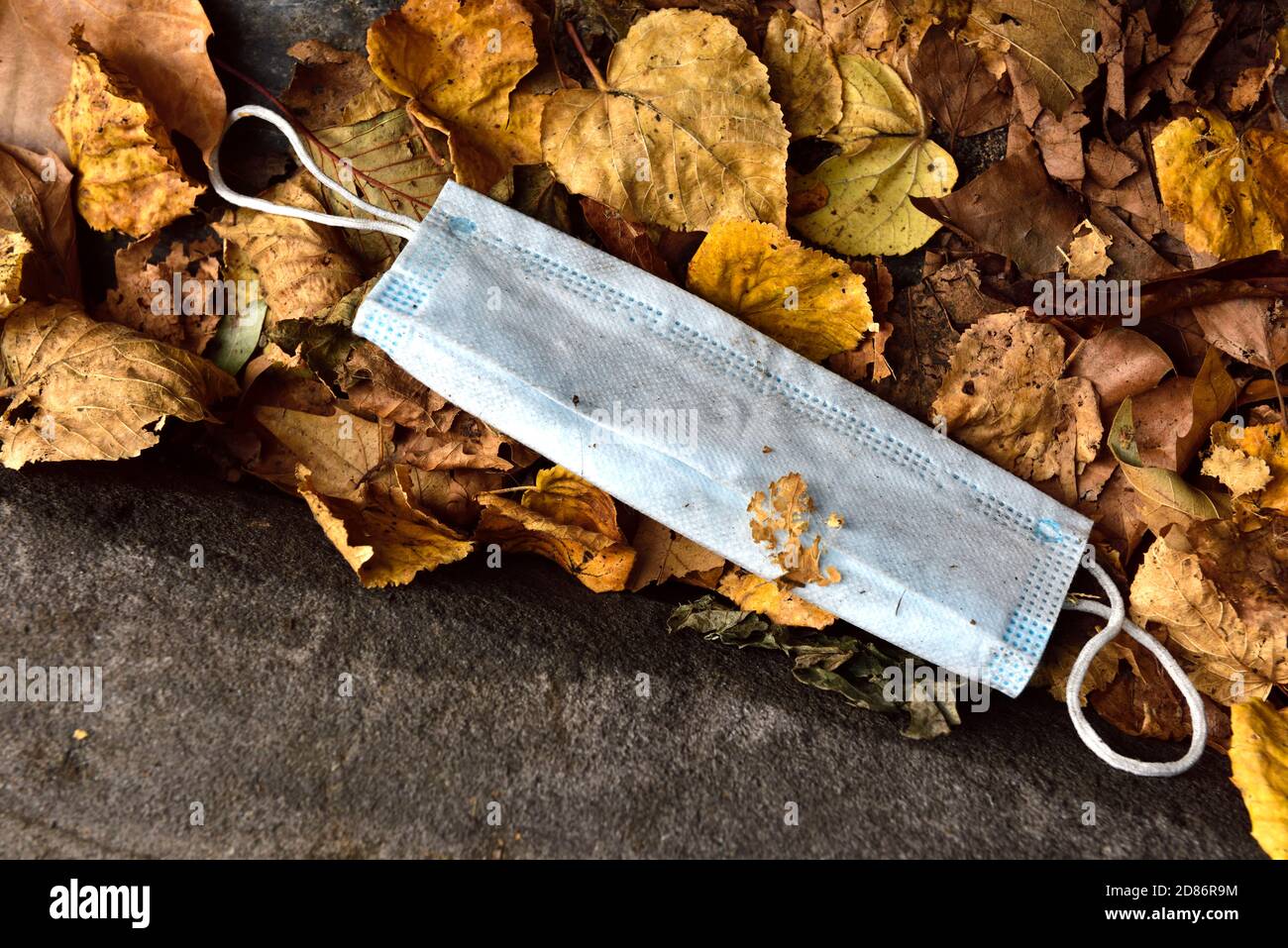 Maschera facciale usa e getta difficilmente utilizzata per la protezione della covid gettata via sulla strada come lettiera, Regno Unito Foto Stock