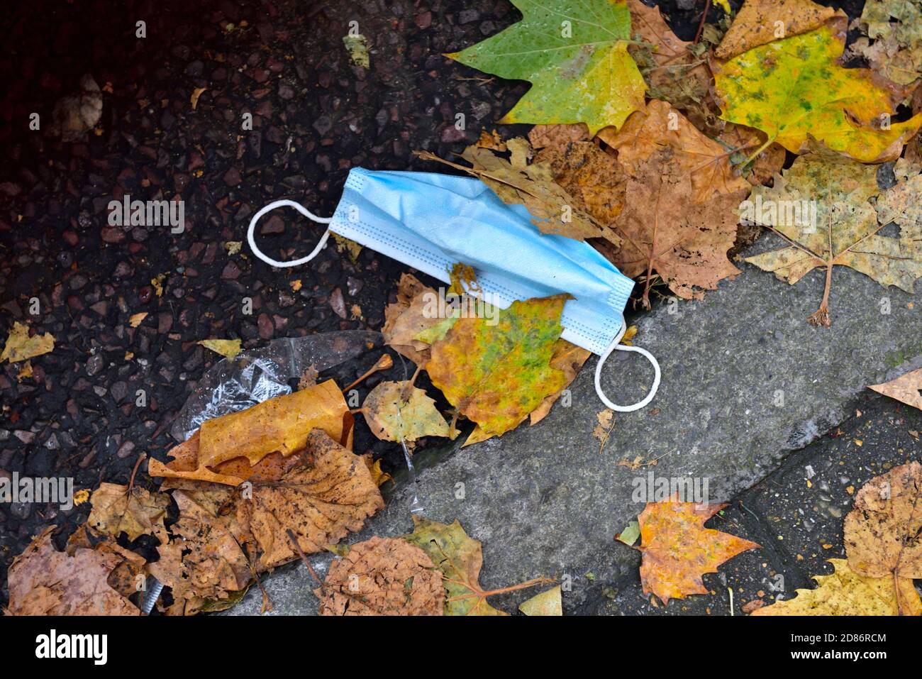 Maschera facciale usa e getta difficilmente utilizzata per la protezione della covid gettata via sulla strada come lettiera, Regno Unito Foto Stock