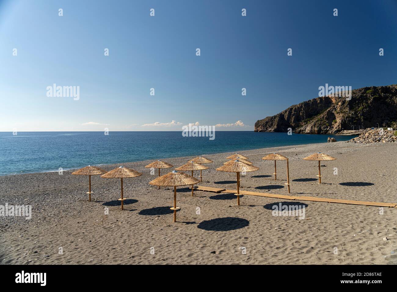 Sonnenschirme am menschenleeren Strand von Sougia im Süden von Kreta, Griechenland, Europa | ombrelloni alla spiaggia deserta di Sougia, Creta, GRE Foto Stock