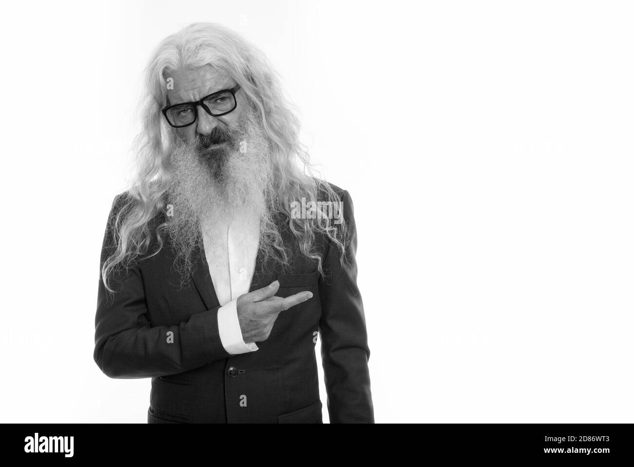 Studio shot di senior barbuto imprenditore guardando disgustato e rivolto di lato Foto Stock