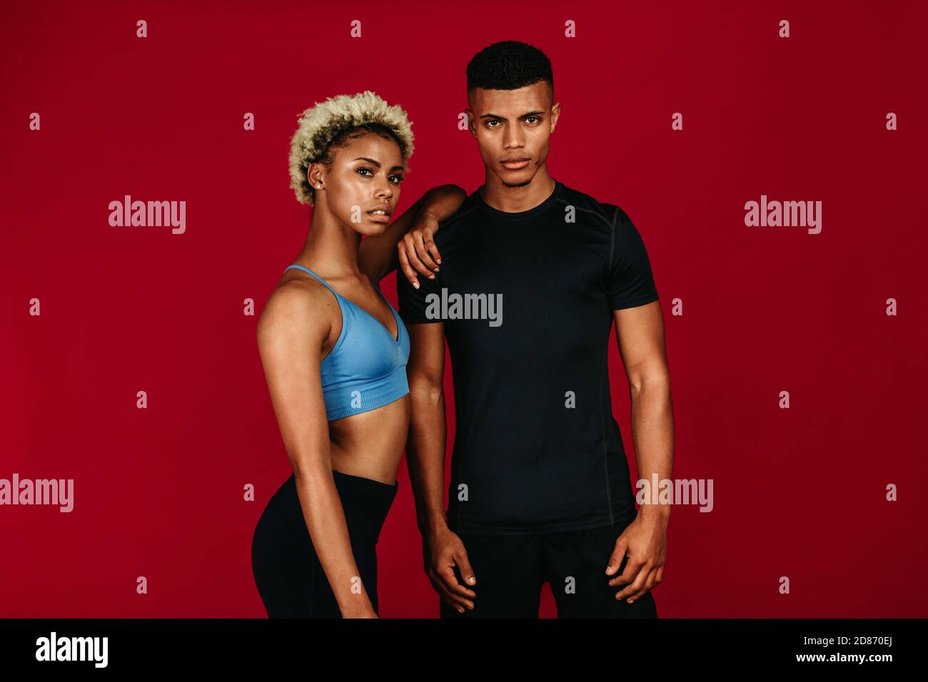 Ritratto di una coppia di fitness afroamericana. Calzare la donna in piedi con il braccio appoggiato sulla spalla dell'uomo muscolare. Foto Stock