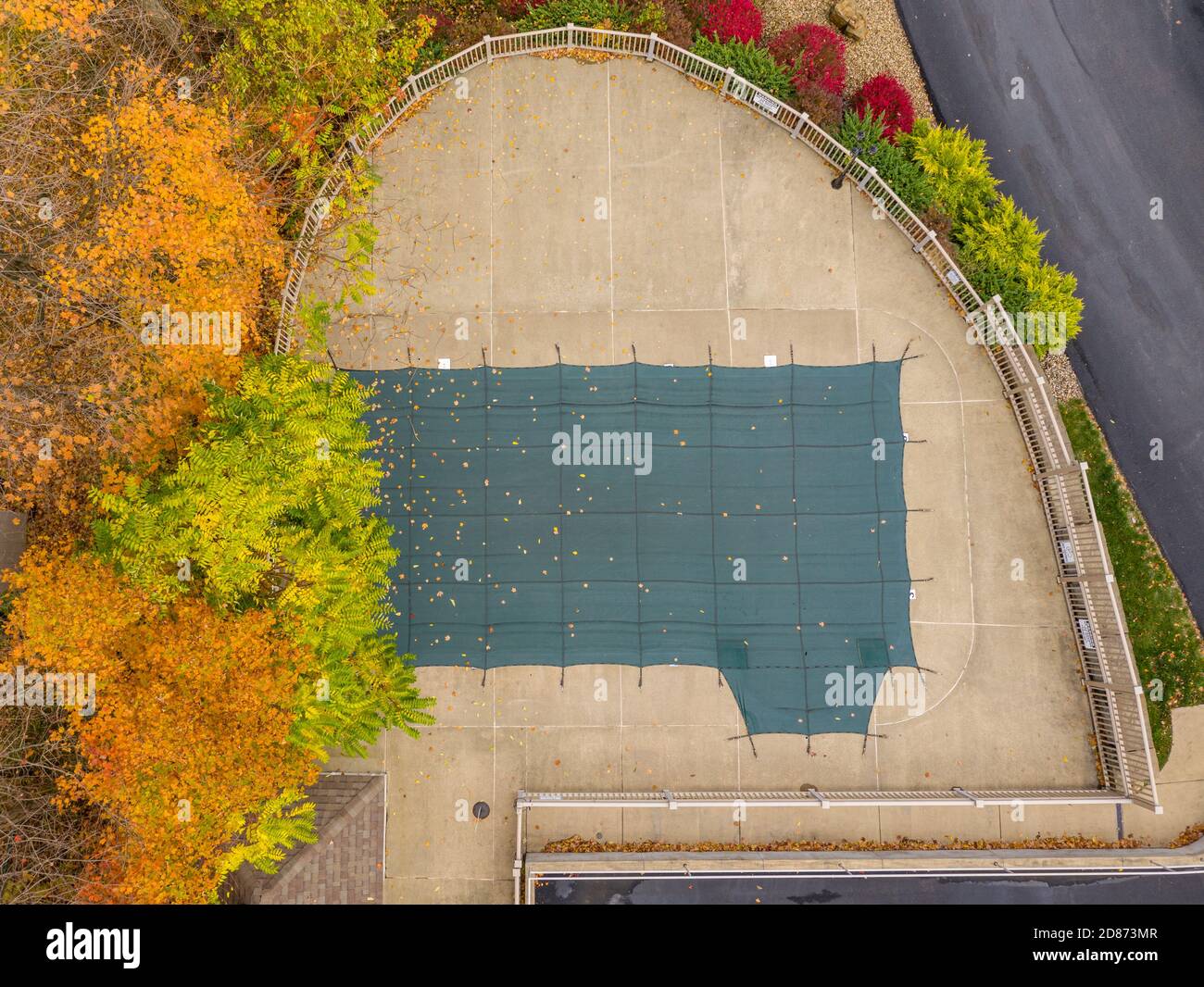 Punto di vista del drone aereo di un coperchio di plastica verde Sulla piscina HOA che la protegge dalle foglie e per le tempeste invernali Foto Stock