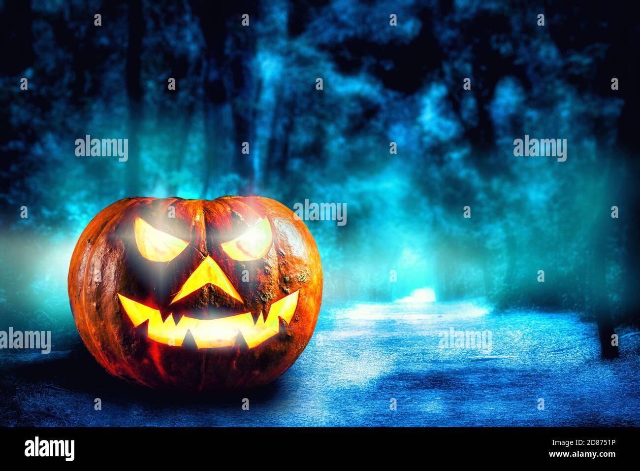 Una foresta mistica spooky a notte di Halloween con un infestato Gli occhi malvagi e luminosi dello spazio di copia della zucca di Jack o' Lanterns Foto Stock