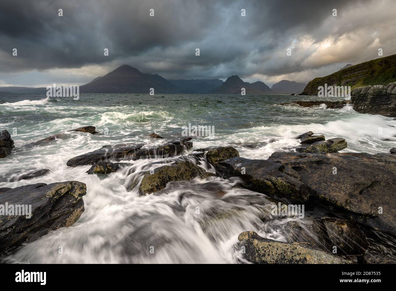 Onde in crash a Elgol sull'isola di Skye con Cuillin Range sullo sfondo. Foto Stock