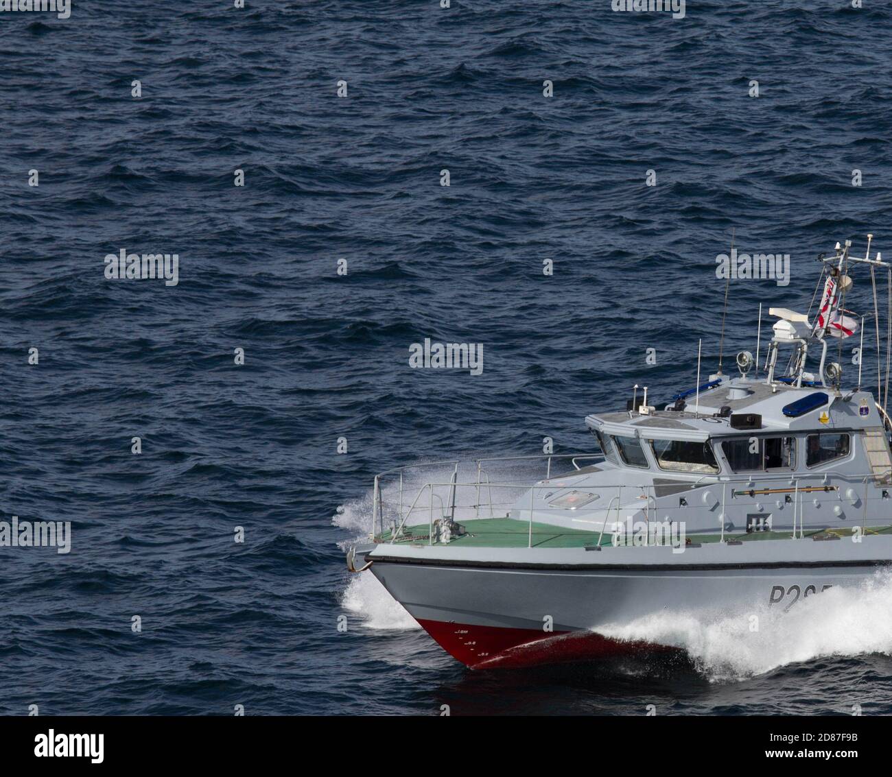 Royal Navy veloce pattuglia barca in corso a velocità attraverso un mare scuro di Gibilterra con onda di arco luminoso. Spazio di copia Foto Stock