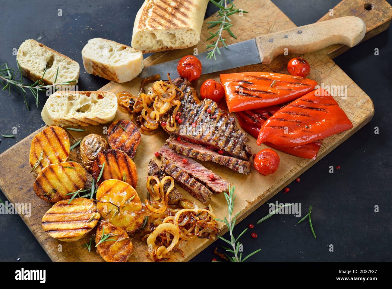 Bistecca di manzo alla griglia con verdure miste e pane italiano croccante Foto Stock