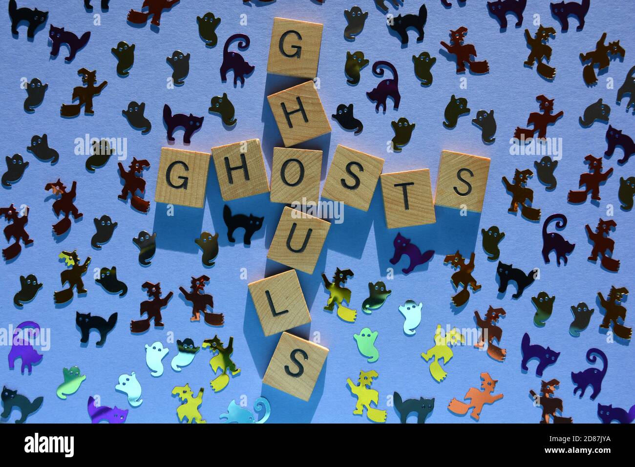 Ghouls, Ghosts, parole in lettere alfabetiche in legno in forma di crossword circondate da forme casuali a tema di Halloween Foto Stock