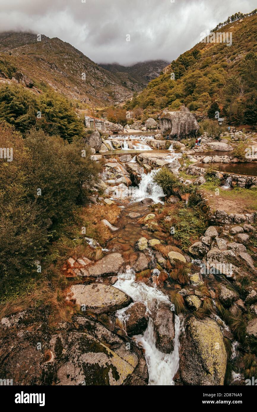 ruscello corre tra rocce con una montagna sullo sfondo Foto Stock