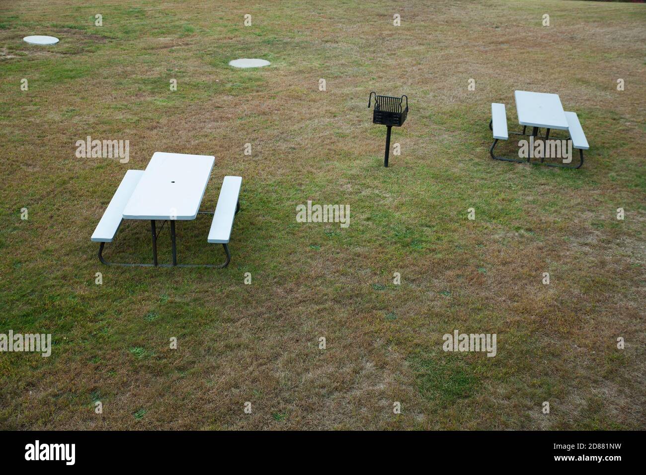 Due tavoli da picnic adeguatamente distanziati per una pandemia. Foto Stock