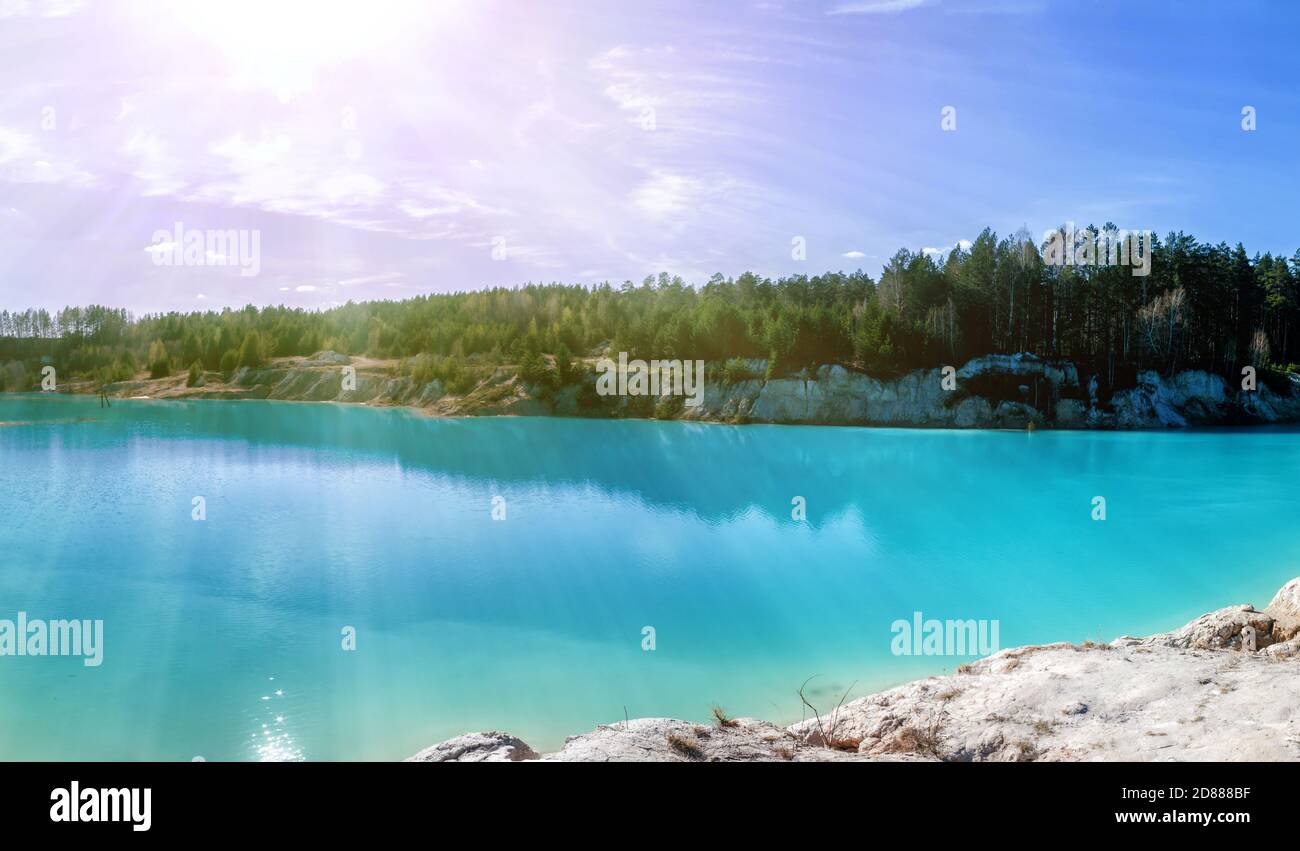 Scenografica cava di argilla allagata con acqua turchese al mattino sole Foto Stock