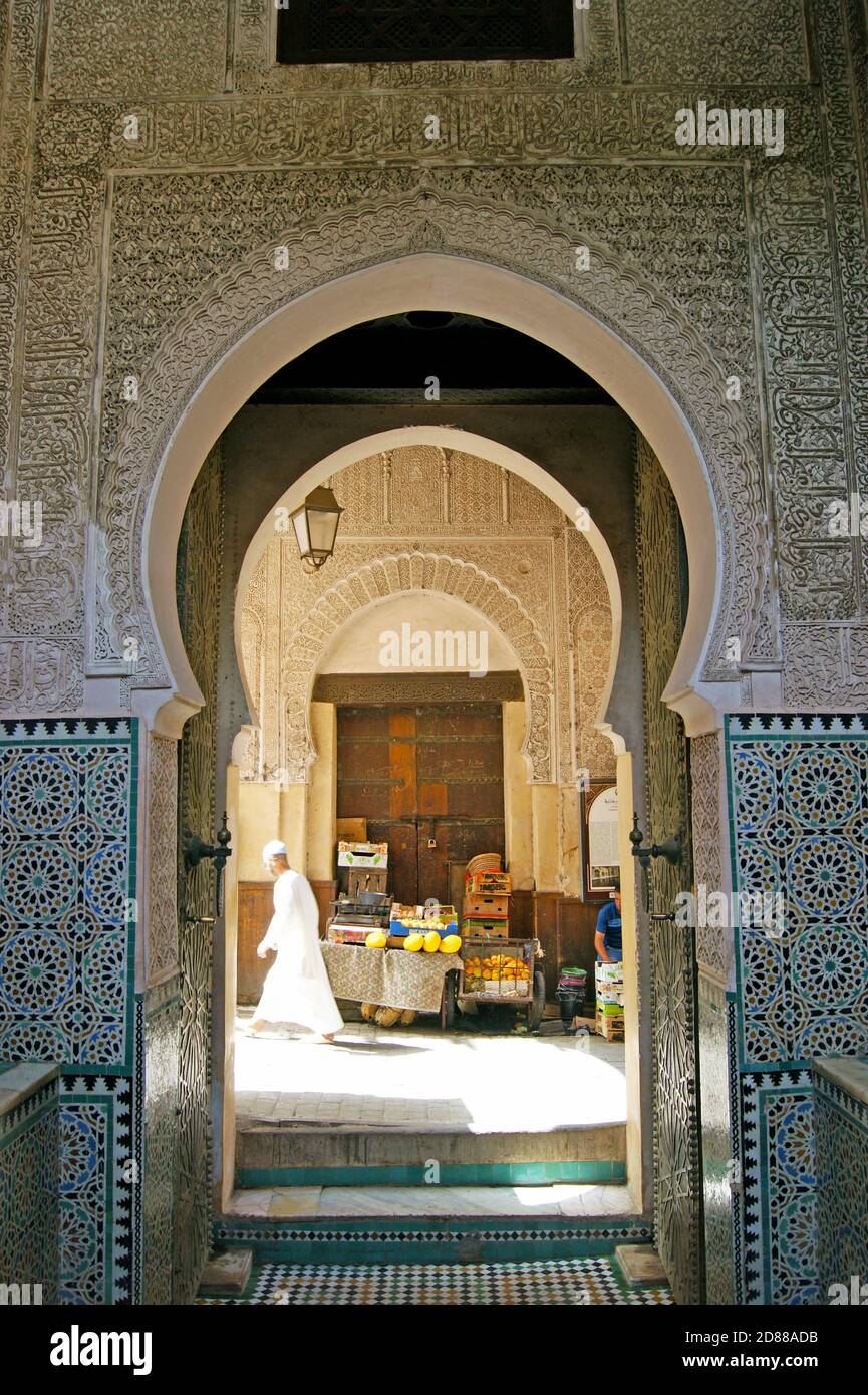 Un uomo cammina davanti a una porta decorata artisticamente in stile moresco nella Medina della città vecchia di Fez il 29 agosto 2013. Foto Stock