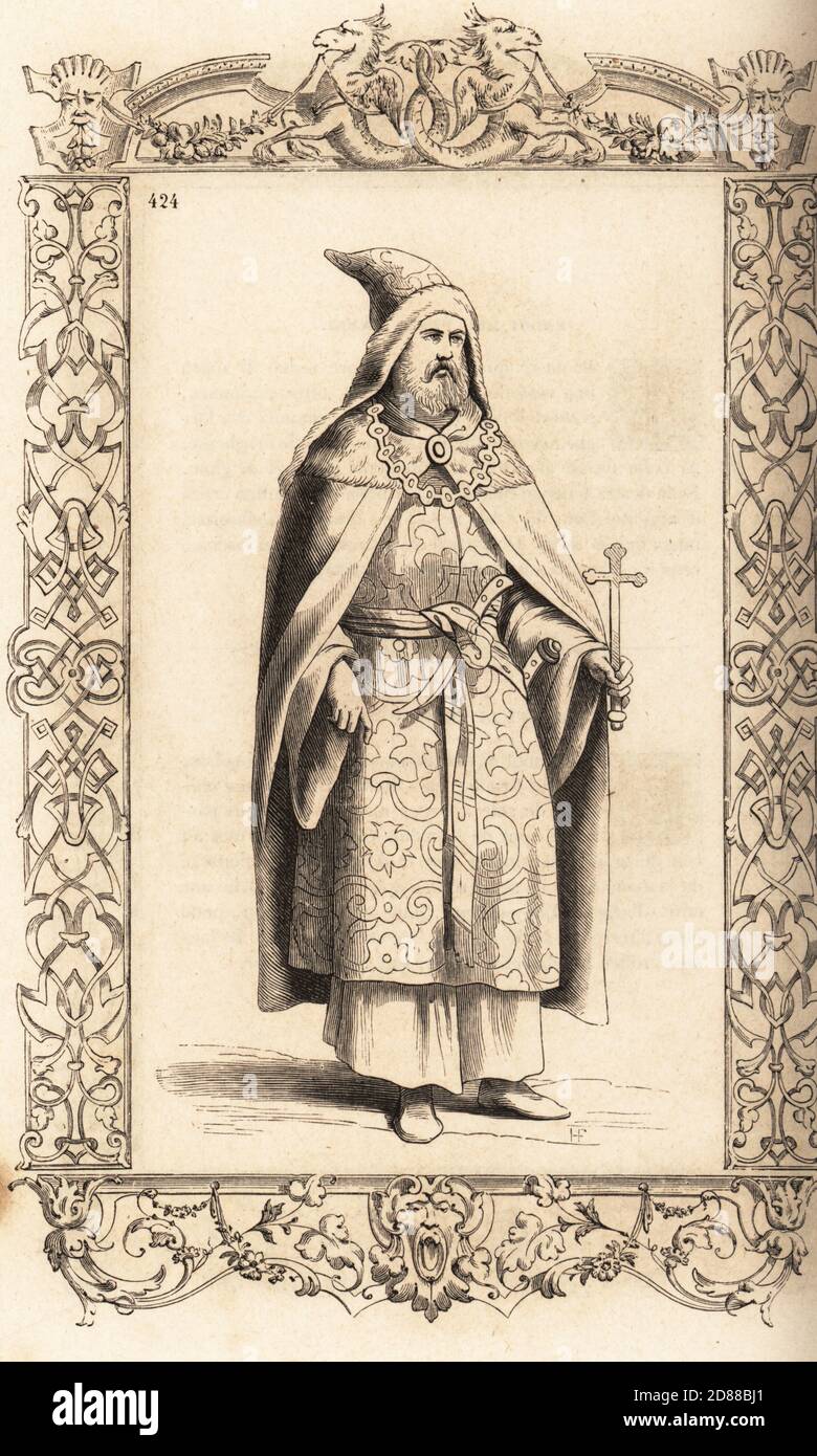 Costume di un sacerdote del leggendario patriarca cristiano Prester John, imperatore d'Etiopia. In capo di pelle animale con cappuccio, collana, chemise di seta, tenendo una croce d'argento. All'interno di una cornice decorativa incisa da H. Catenacci e Fellmann. Incisione di blocchi di legno di Gerard Seguin e E.F. Huyot dopo un taglio di legno di Christoph Krieger dai costumi di Cesare Vecellio del XVI secolo anciens et modernes, Habiti antichi et moderni di tutto il mondo, Firman Didot Ferris Fils, Parigi, 1859-1860. Foto Stock