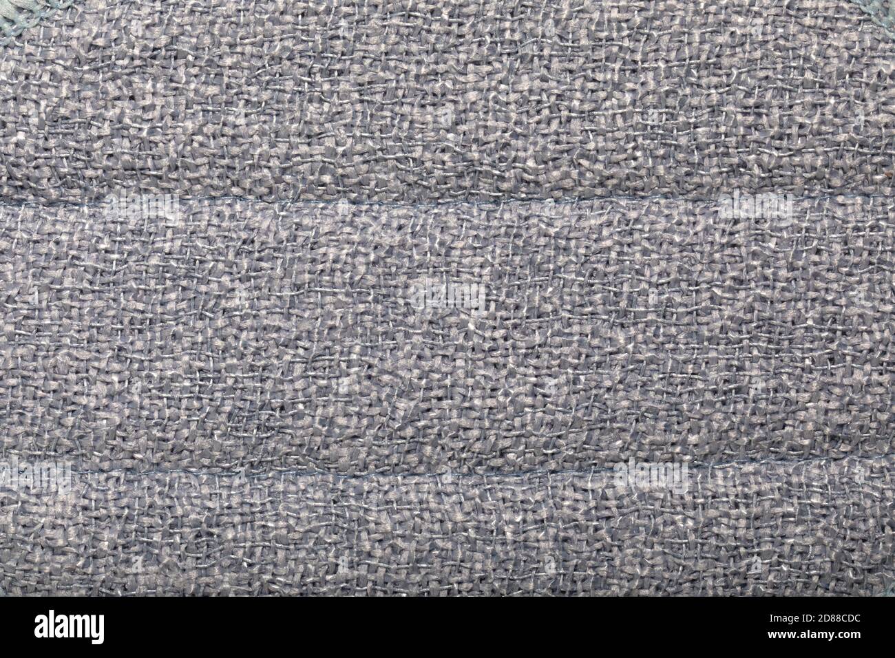 Tessuto grigio tessuto vimini. Tessuto grigio ruvido con interlacciatura primo piano come sfondo Foto Stock