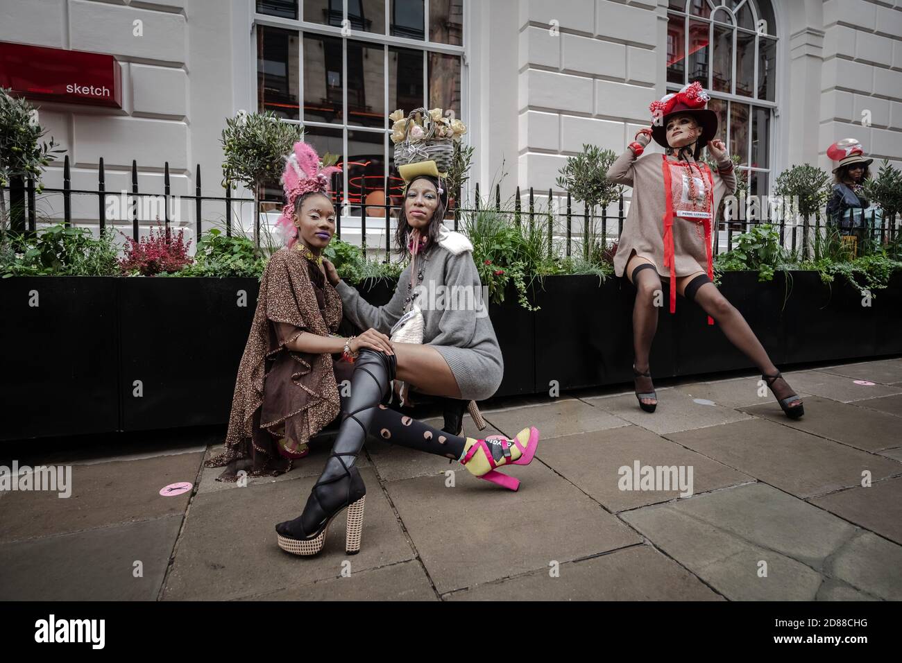 I modelli prendono parte a una colorata sfilata di moda di strada flashmob vicino a Savile Row per lo stilista Pierre Garroudi. Londra, Regno Unito. Foto Stock
