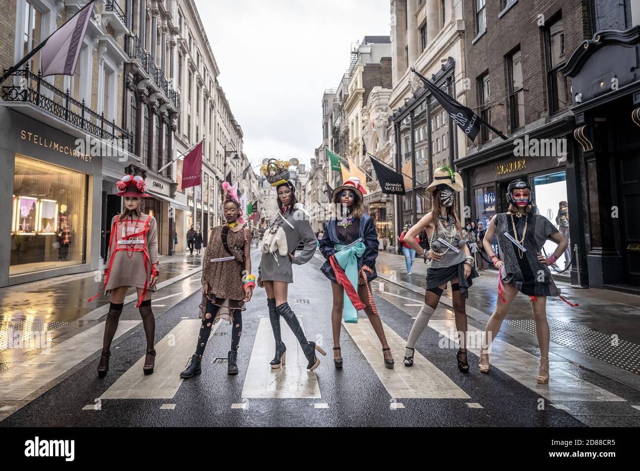 I modelli prendono parte a una colorata sfilata di moda di strada flashmob vicino a Savile Row per lo stilista Pierre Garroudi. Londra, Regno Unito. Foto Stock