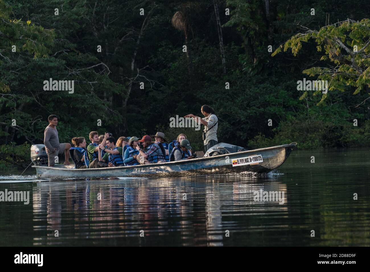 Una barca piena di ecotouristi e le loro guide ecuadoriane nella riserva naturale di Cuyabeno in Ecuador. Foto Stock