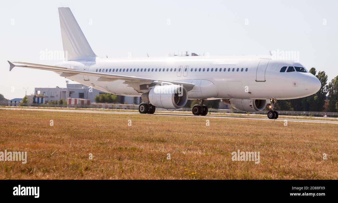 Un aereo bianco sulla pista dell'aeroporto sta tassando. Decollo e atterraggio. Arrivo e partenza. Posiziona per il testo. Mockup isolato dell'aereo del passeggero. Aereo Foto Stock