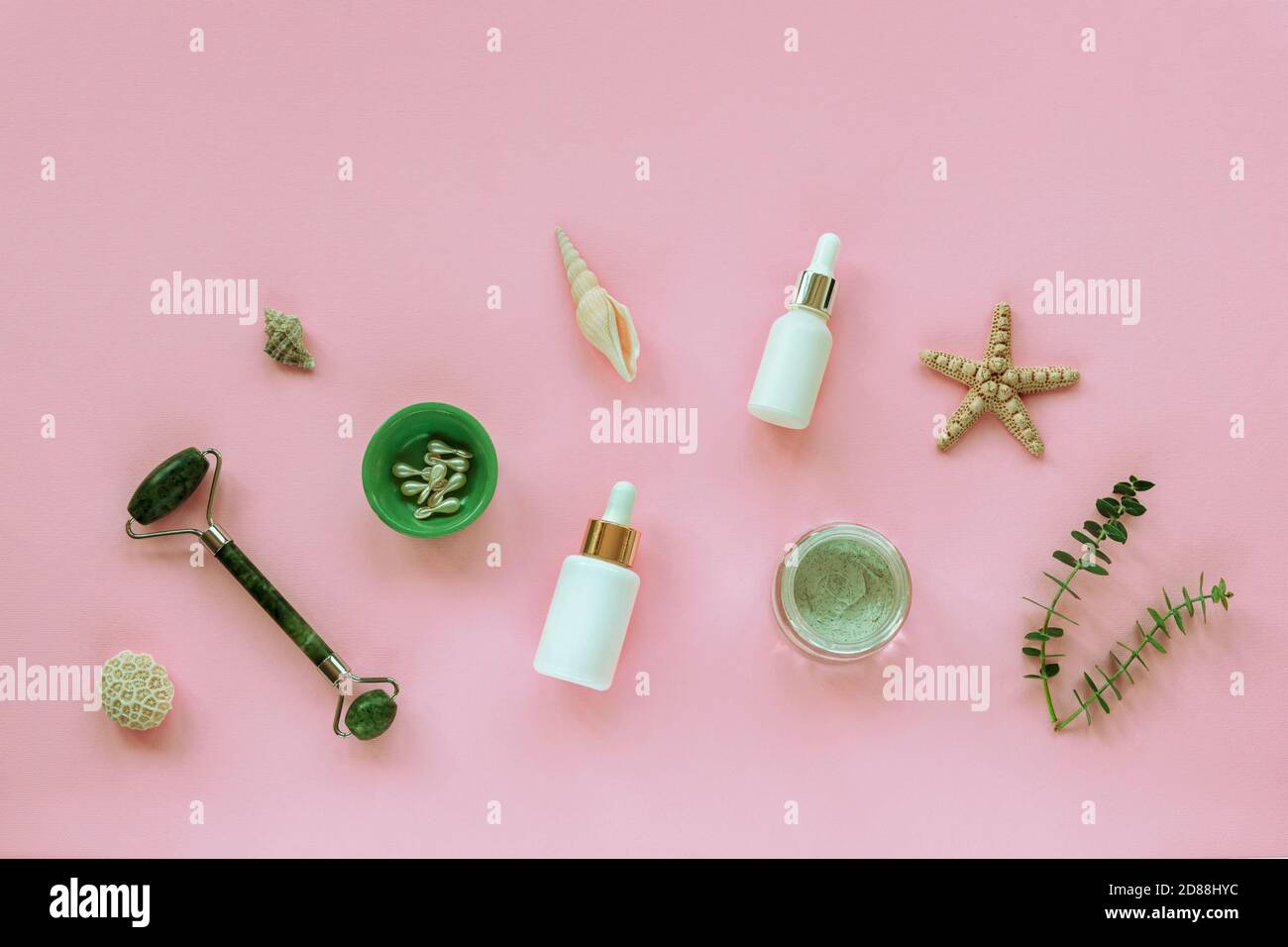 Prodotti naturali biologici per la cura della pelle. Siero, vasetto di crema, capsule di bellezza flaconi bianchi senza marchio. Starfish, Face Roller, seashell e eucalipto sp Foto Stock