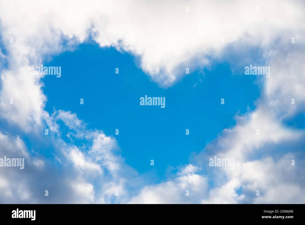 Cuore reale dalla nuvola nel cielo blu. San Valentino. Simbolo dell'amore Foto Stock