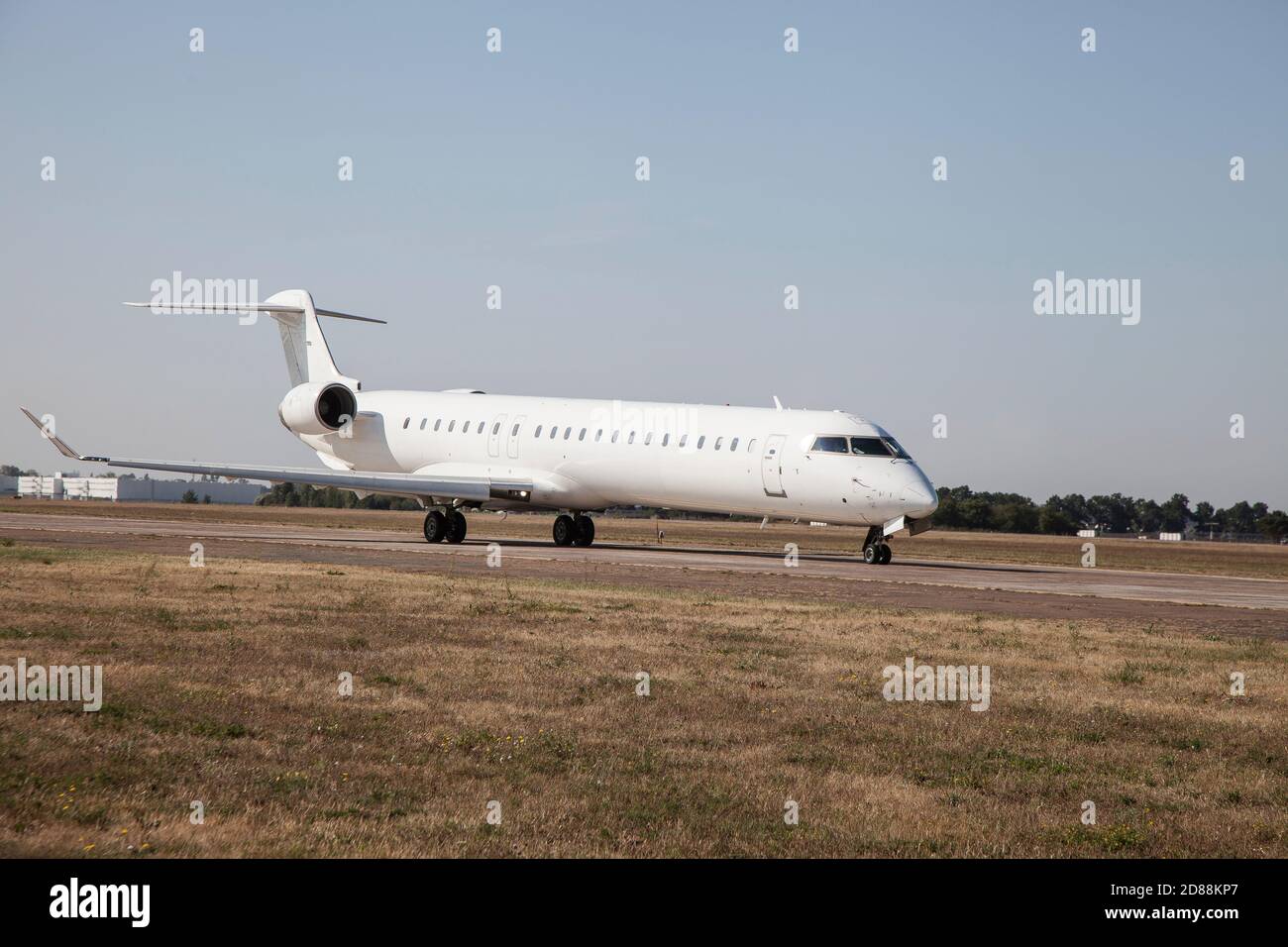 Un aereo bianco sulla pista dell'aeroporto sta tassando. Decollo e atterraggio. Arrivo e partenza. Posiziona per il testo. Mockup isolato dell'aereo del passeggero. Aereo Foto Stock