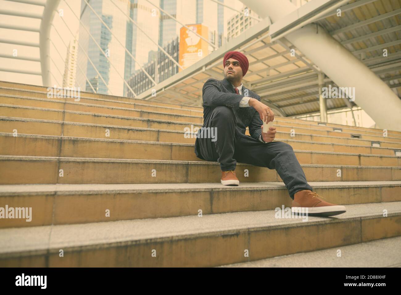 Giovane bell'uomo d'affari indiano Sikh che indossa il turbante mentre esplorando il città Foto Stock