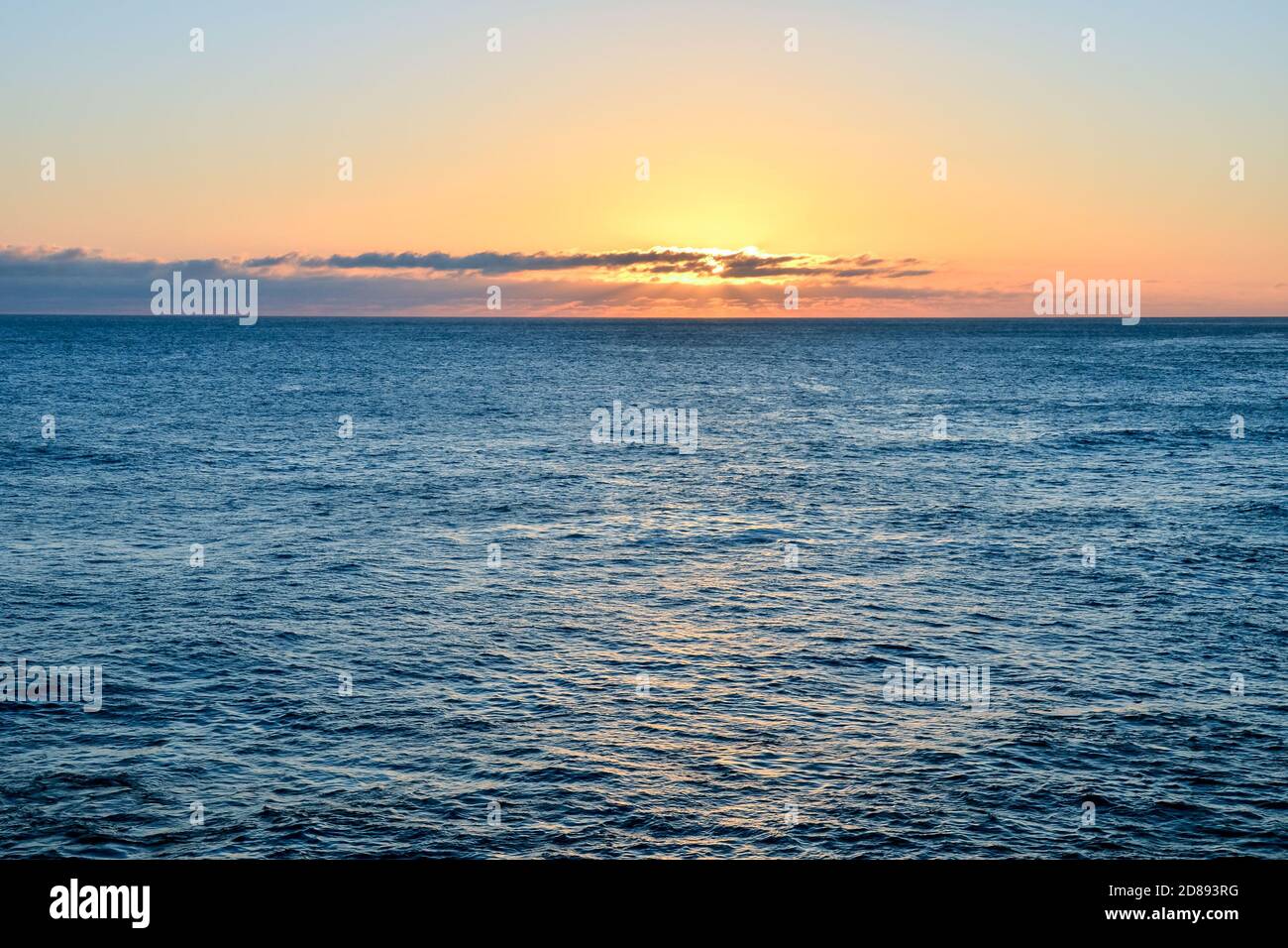 Il sole che tramonta nel mare Foto Stock