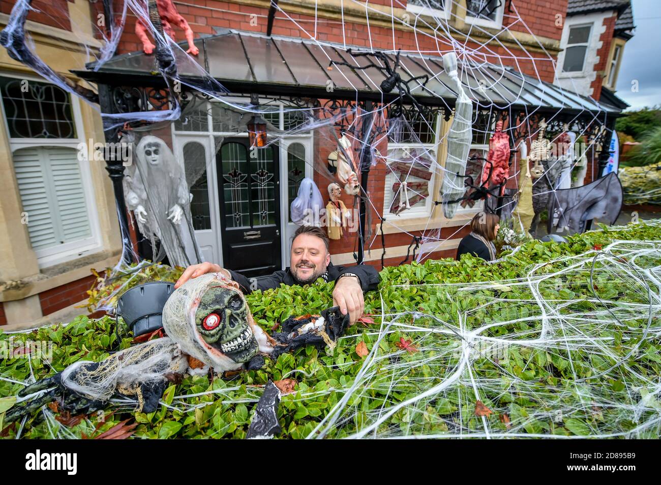 Danny Hargreaves regola un cranio ghoulish su una siepe nella sua casa di famiglia a Llandaff, vicino a Cardiff, che è decked fuori e ornato con i punteggi di decorazioni realistiche di Halloween, installato da Danny, che lavora in TV effetti speciali. Foto Stock