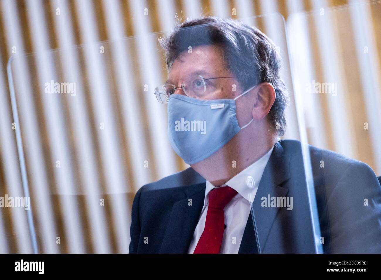 Schwerin, Germania. 28 Ott 2020. Reinhard Meyer (SPD), ministro delle Finanze del Meclemburgo-Pomerania occidentale, segue il dibattito in parlamento con la protezione della bocca e del naso e dietro un muro di plexiglas il dibattito sul bilancio suppletivo del governo statale 2020/2021 per far fronte alle conseguenze della crisi della corona. Il bilancio suppletivo prevede l'assunzione di 2.15 miliardi di euro di nuovo debito, il che significherebbe il più alto livello di debito nella storia del Meclemburgo-Vorpommern a 12.2 miliardi di euro. Credit: Jens Büttner/dpa-Zentralbild/dpa/Alamy Live News Foto Stock