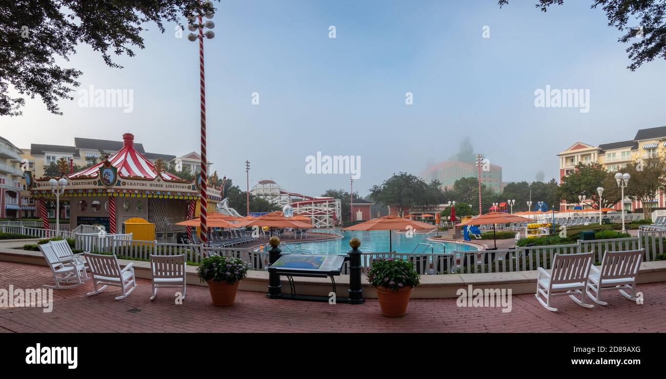 La nebbia mattutina oscura parzialmente il Walt Disney World Swan Hotel dall'altra parte della piscina del Disney's Boardwalk Inn, Florida Foto Stock