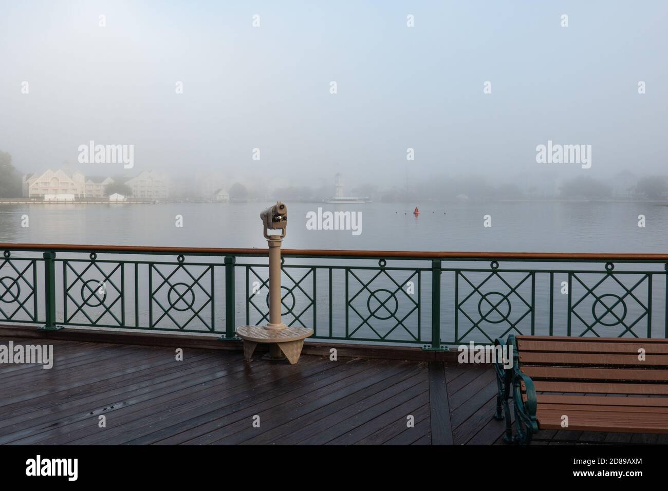 La nebbia mattutina oscura parzialmente gli Yacht e Beach Club Resorts Disney dall'altra parte del lago presso il Disney's Boardwalk Inn, Florida Foto Stock