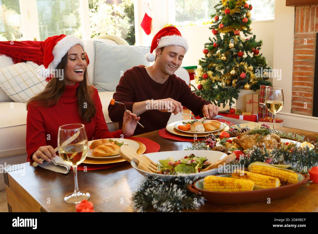 Coppia seduta e pranzo insieme mentre si siede nella soggiorno a casa Foto Stock