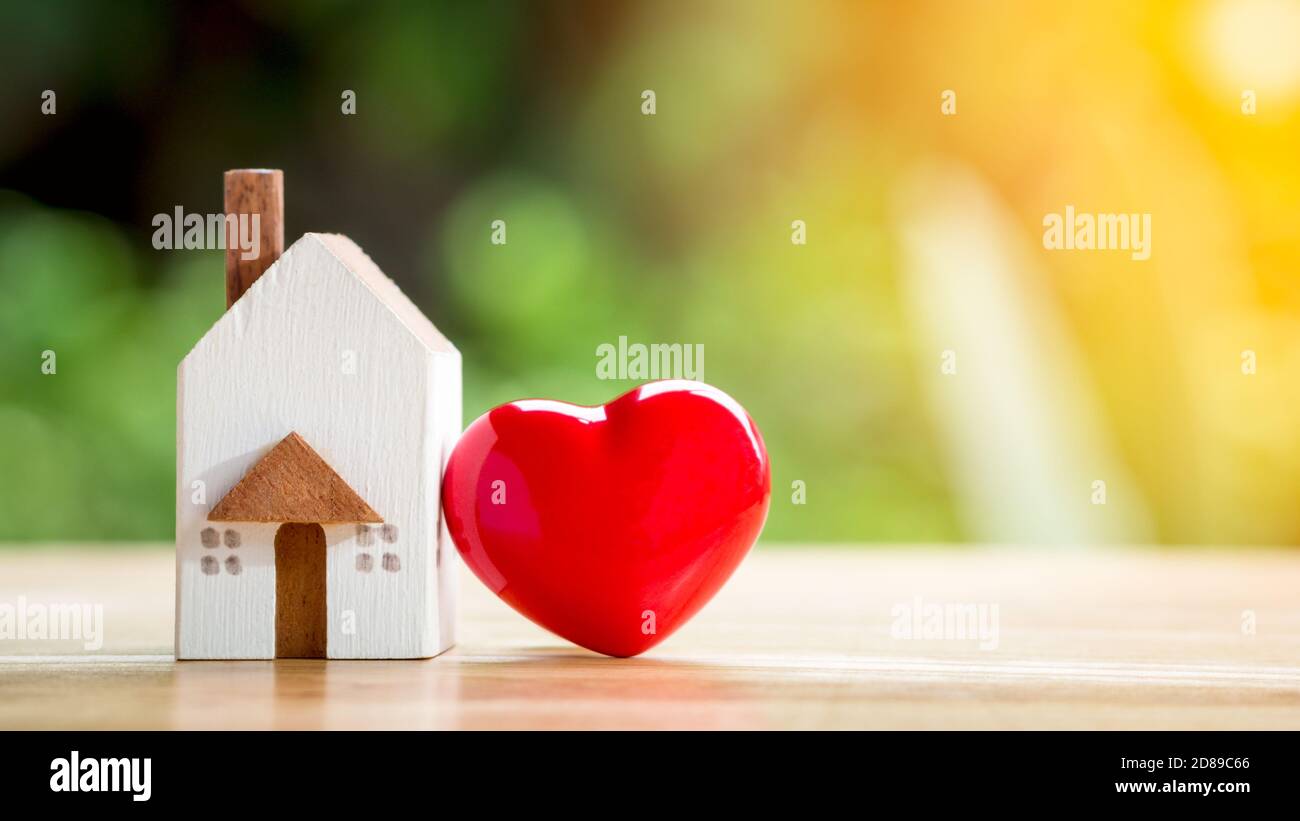 Casa o casa con cuore rosso sul lato invece di un mezzo d'amore. Amore minimo e concetto di San Valentino. Madri giorno piatto laici. Foto Stock