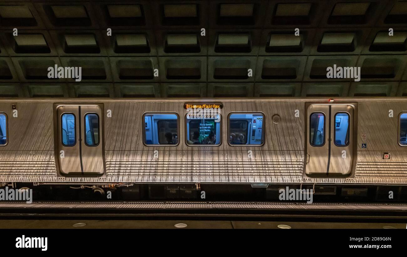 Un treno della metropolitana linea Orange Vienna/'Fairfax si trova sotto il soffitto a cassettoni in cemento della McPherson Square Station, Washington DC. Foto Stock