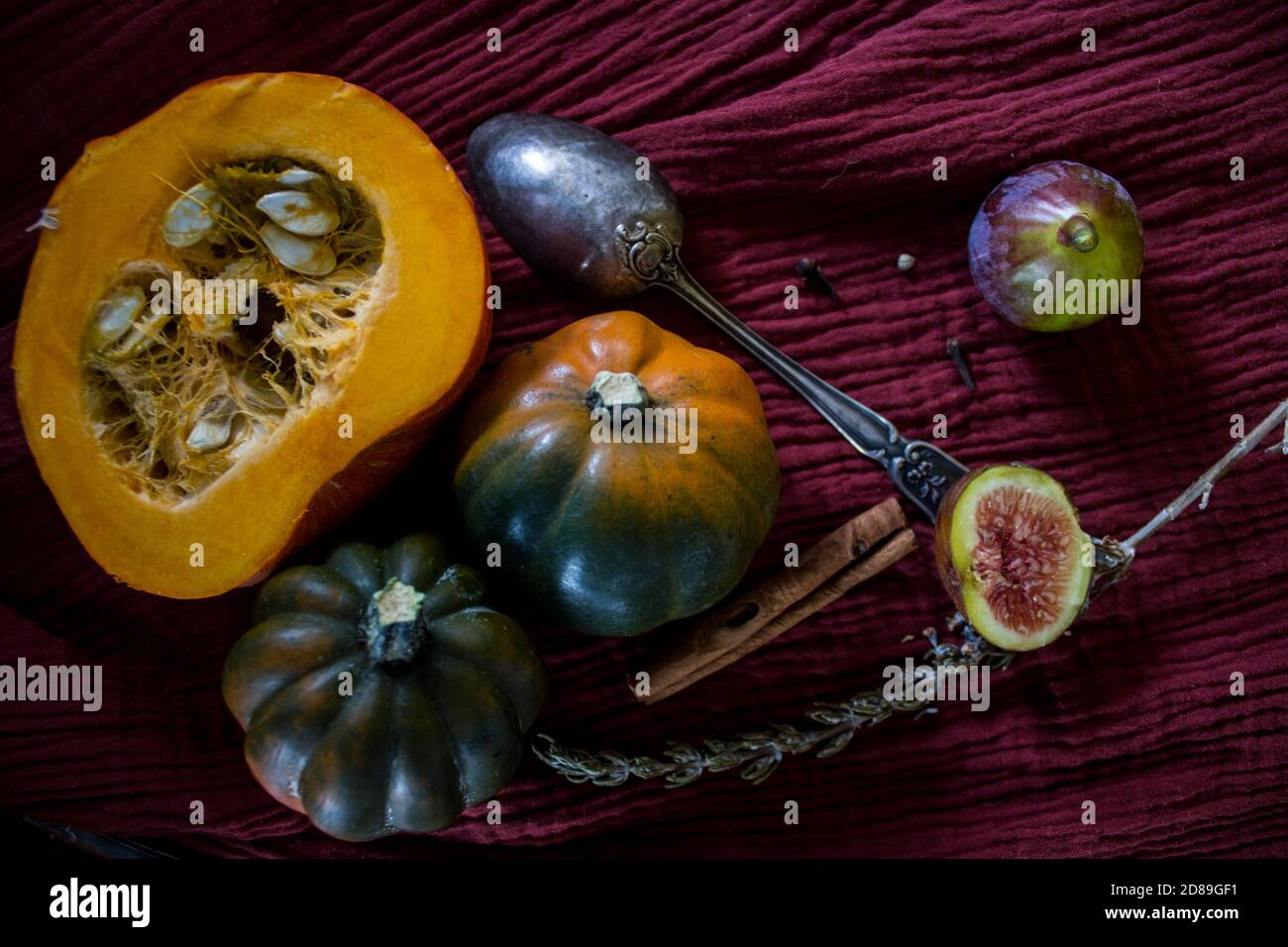 Foto dall'alto di butternut, zucca gemma, zucca, nocciolo dorato, carota, fichi, patate dolci, cipolla, arance e prezzemolo. Concetto di alimentazione sana. Foto Stock