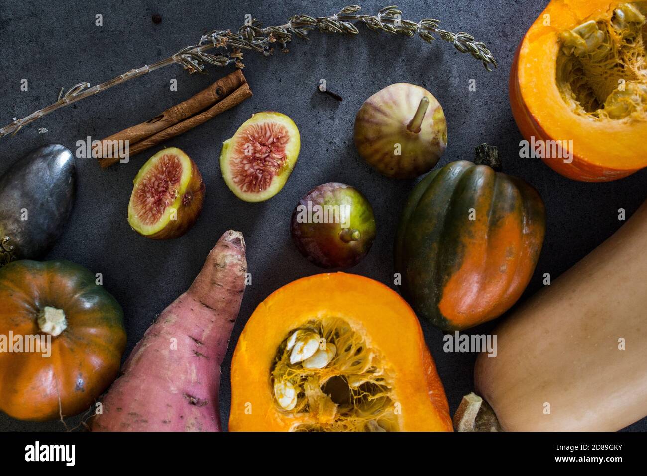 Verdure fresche su sfondo grigio con spazio per la copia. Foto dall'alto di butternut, zucca gemma, carota di zucca d'oro, fichi, patate dolci, cipolla. Foto Stock