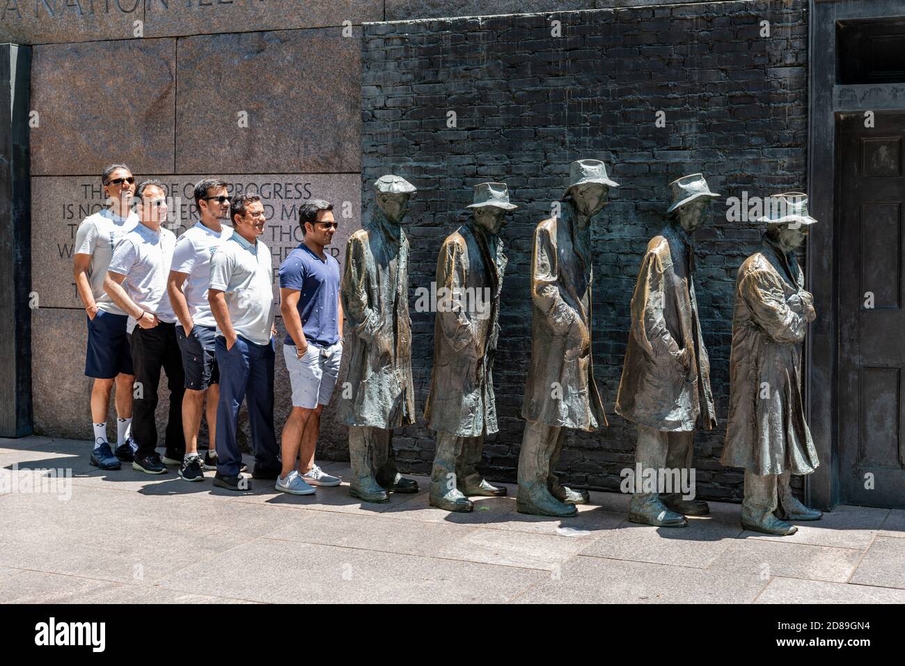Un gruppo di turisti indiani si uniscono al Breadline, la scultura della Grande depressione di George Segal al Franklin Delano Roosevelt Memorial. Foto Stock