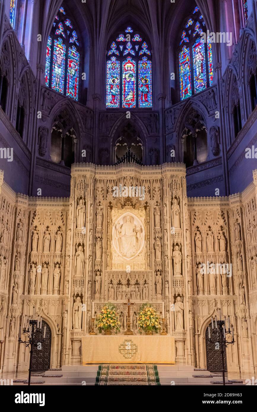 Colorate vetrate colorate all'estremità est della navata centrale della Cattedrale Nazionale di Washington incorniciano l'altare maggiore intagliato in modo intricato sotto. Foto Stock