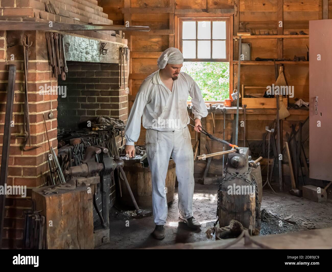 Una guida in costume mostra come modellare una barra di ferro nella ricostruzione del 2009 del 18 ° C. Blacksmith's Shop al George Washington's Mount Vernon. Foto Stock