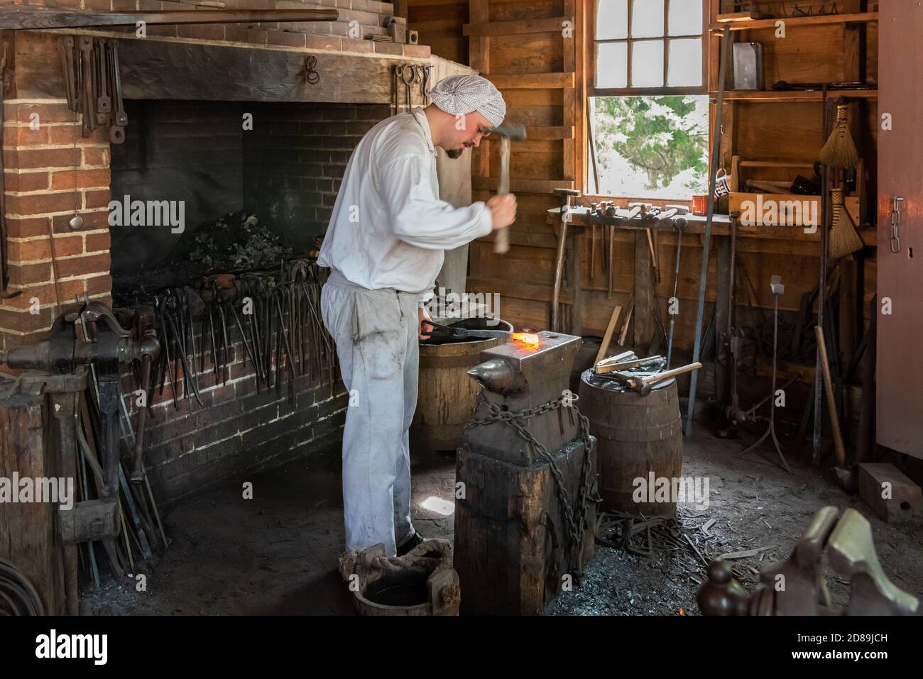 Una guida in costume mostra come modellare una barra di ferro nella ricostruzione del 2009 del 18 ° C. Blacksmith's Shop al George Washington's Mount Vernon. Foto Stock