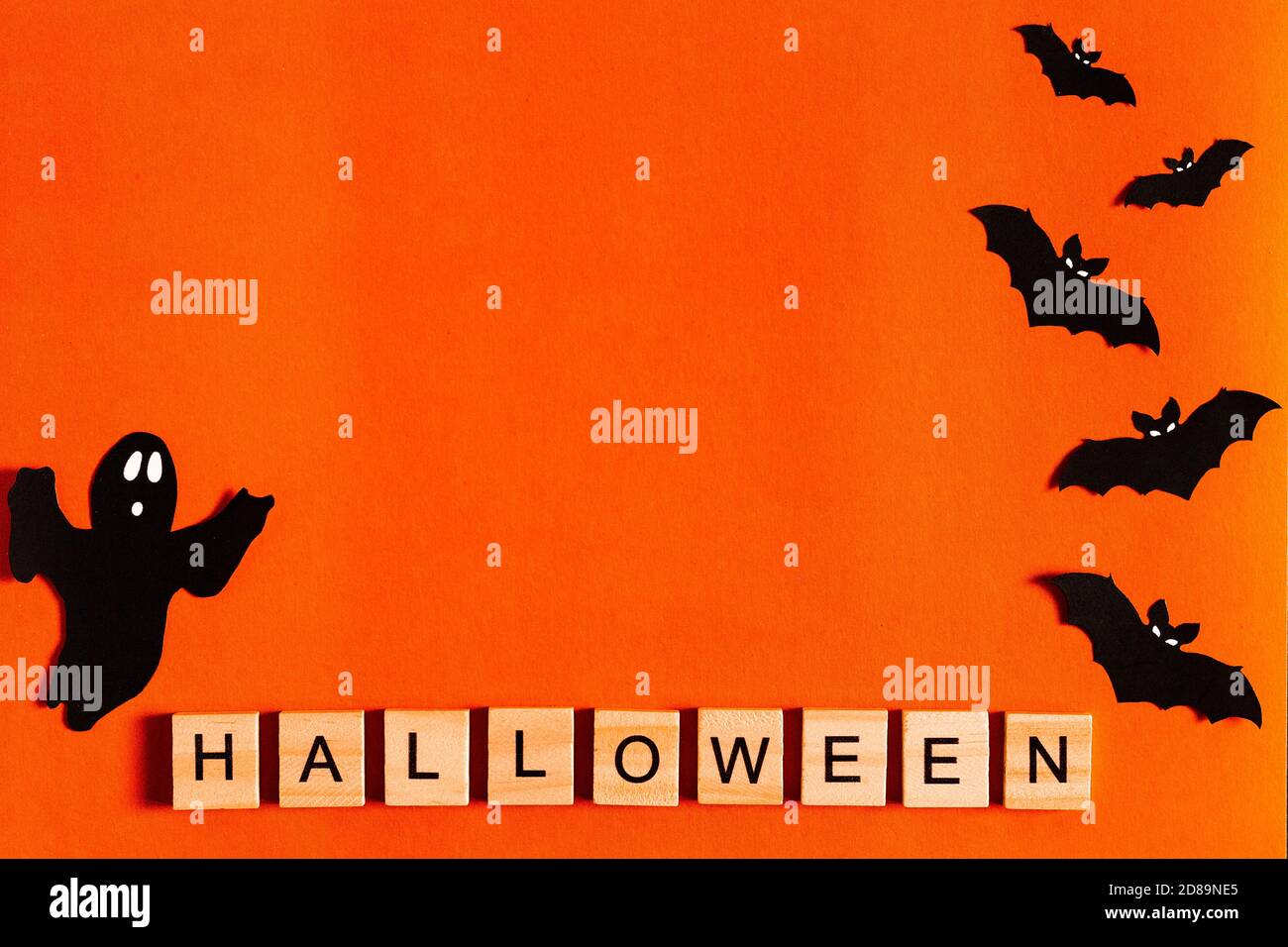 Scritta Halloween su sfondo arancione con silhouette di carta nera, pipistrelli, zucca, ragno. Il concetto di Halloween. La vista dall'alto Foto Stock