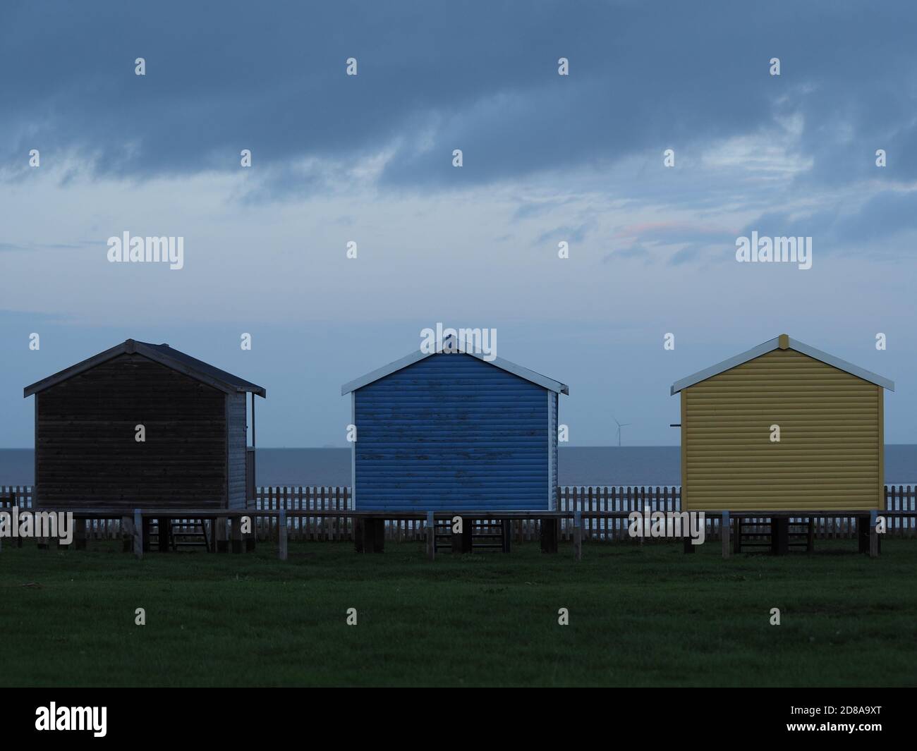 Leysdown, Kent, Regno Unito. 28 ottobre 2020. UK Weather: Nuvole di pioggia oscure minacciose si profilano sulle capanne della spiaggia a Leysdown, Kent questa sera. Credit: James Bell/Alamy Live News Foto Stock