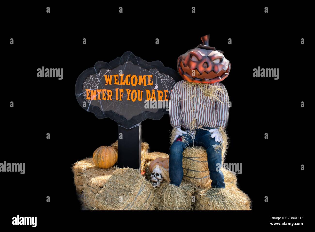 Decorazione d'ingresso di Halloween con uomo spooky con testa di zucca seduta su covoni di fieno con segno 'Benvenuto, entra se osate', sfondo nero. Foto Stock