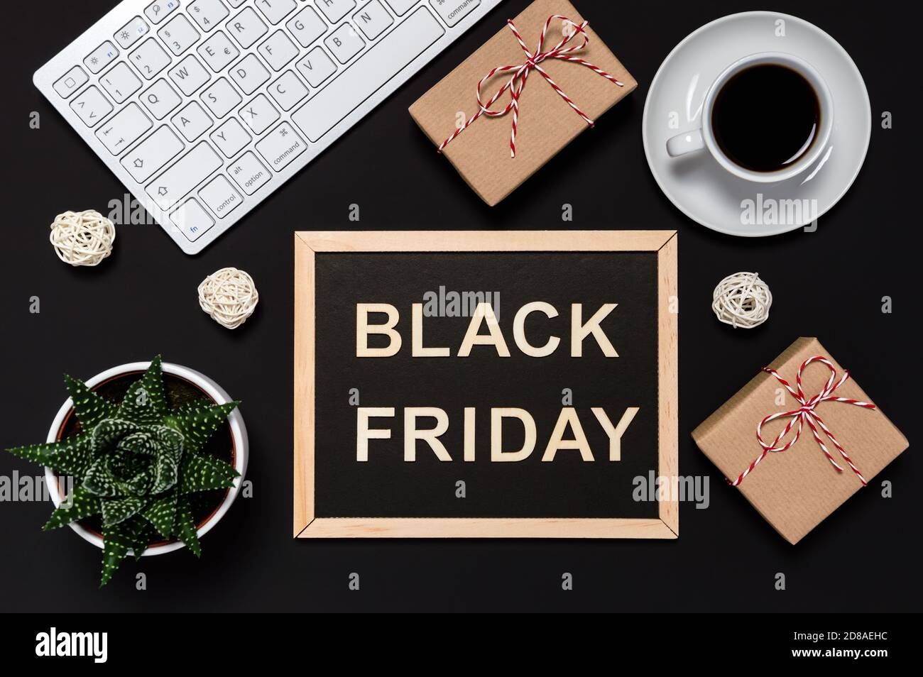 Offerta Black Friday. Presenta, caffè, tastiera e lavagna con parole in lettere di legno su sfondo scuro. Concetto di shopping online. A posa piatta, Foto Stock