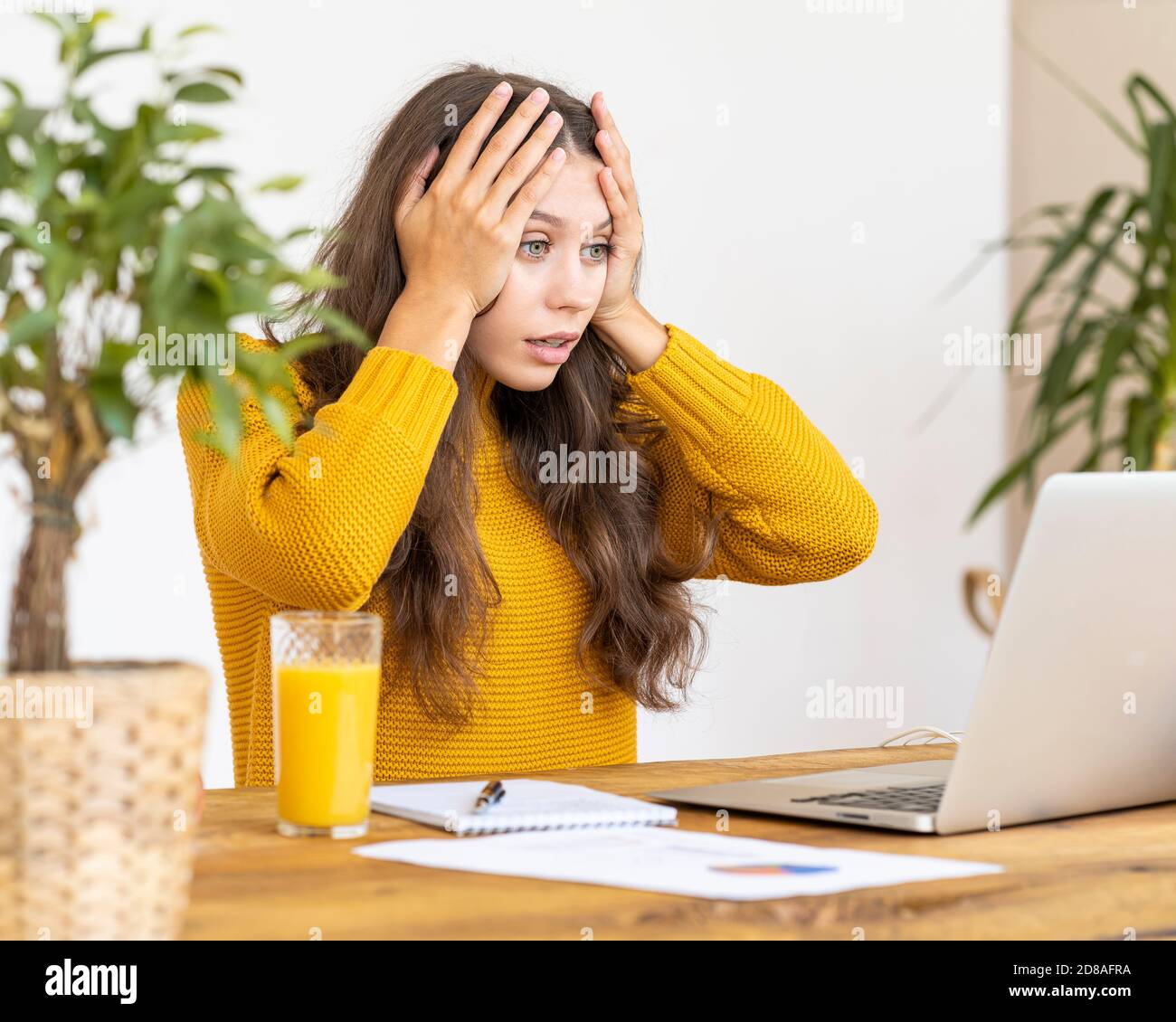 Ragazza sorprendente, sconvolto, orrore in faccia. Bella giovane donna che lavora su un computer portatile Foto Stock