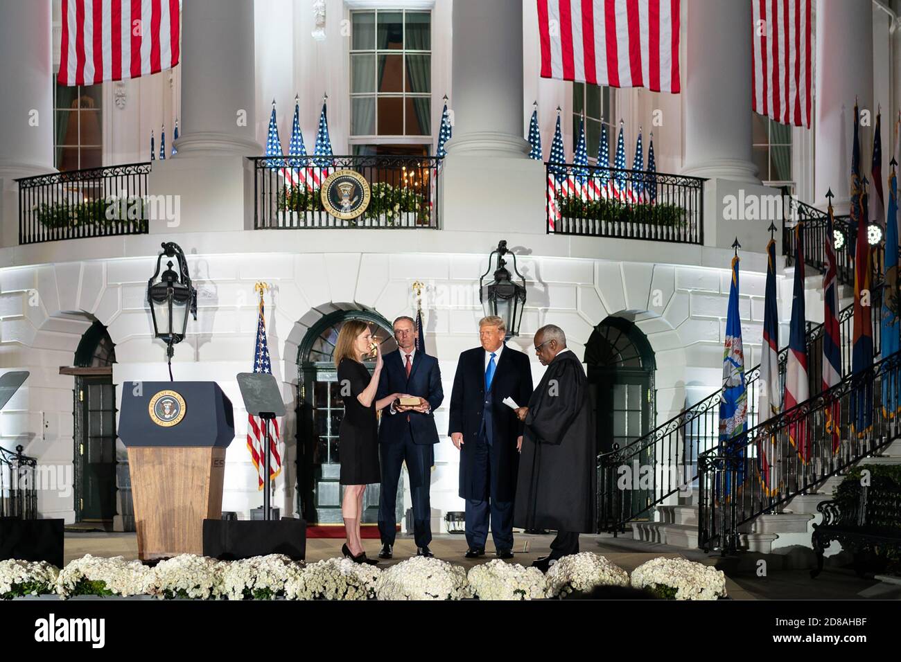 Il presidente Donald J. Trump guarda sopra come l'associato di giustizia della Corte Suprema degli Stati Uniti Clarence Thomas Giura nel giudice Amy Coney Barrett per essere la giustizia associata della Corte Suprema 115th lunedì, ottobre 23, 2020, sul prato del sud della Casa Bianca a Washington, La Giustizia di D.C. Barrett è unita da suo marito Jesse, che tiene la Bibbia, e i loro figli. (STATI UNITI) Foto Stock