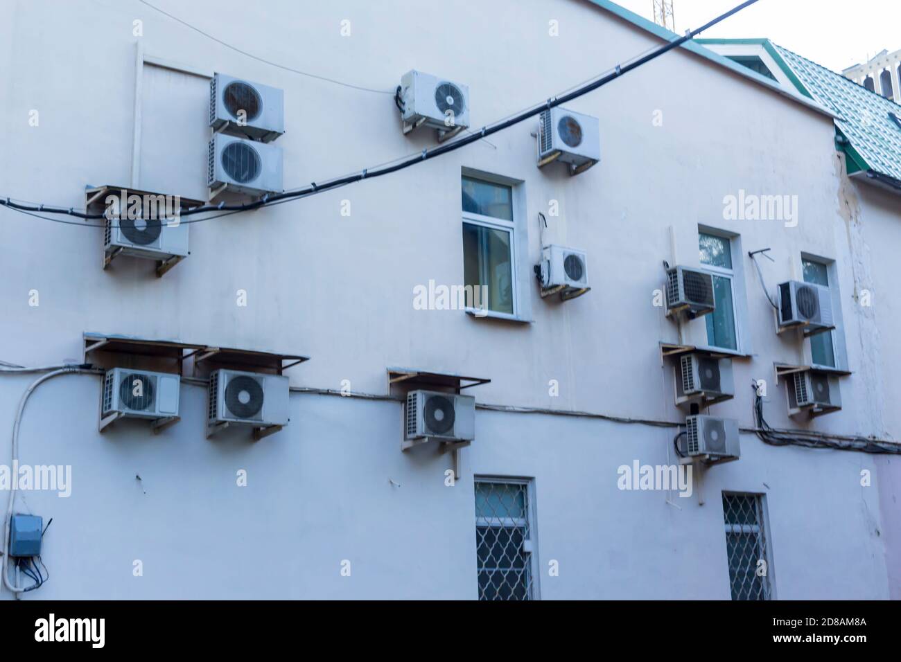 Condizionatori d'aria sul muro della casa in cui si trovano gli uffici. Casse di blocchi esterni di varie forme. Foto Stock